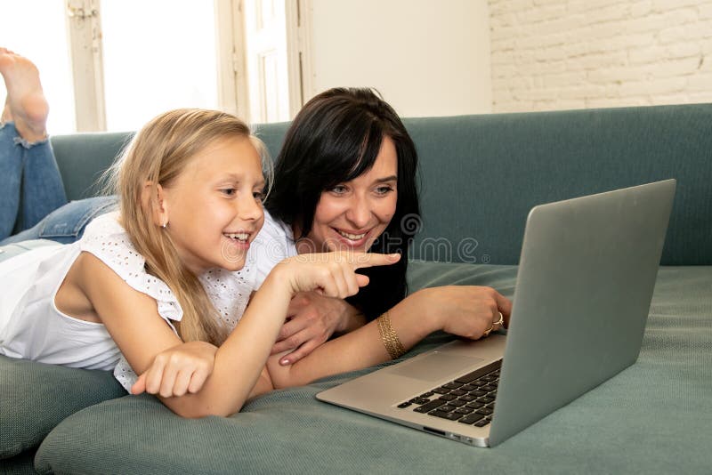 Madre e figlia che sorridono e che si divertono insieme gioco e praticare il surfing su Internet su un computer portatile immagine stock Madre e figlia che sorridono e che si divertono insieme gioco e praticare il surfing su Internet su un computer portatile immagine stock