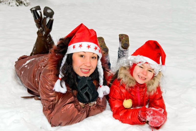 Madre e figlia in protezioni del Babbo Natale fotografie stock libere da diritti Madre e figlia in protezioni del Babbo Natale fotografie stock libere da diritti