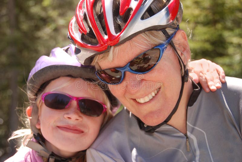 Madre e hija en cascos de la bicicleta