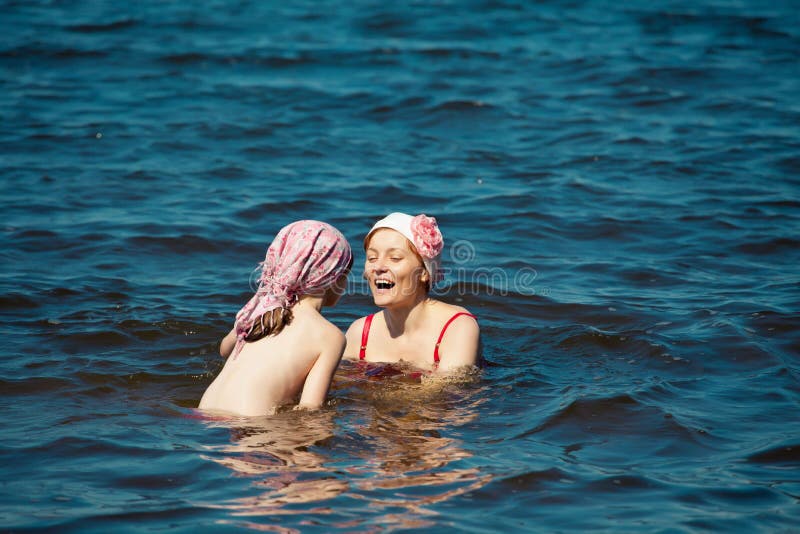 Madre e hija que juegan en el mar fotos de archivo libres de regalías Madre e hija que juegan en el mar fotos de archivo libres de regalías