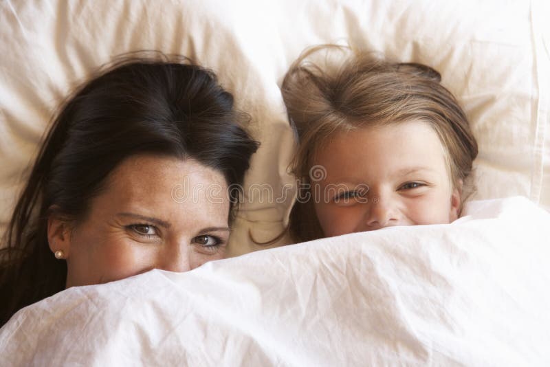 Madre e hija que ocultan debajo de las ropas de cama