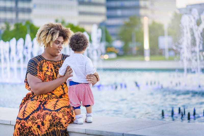 Madre e hija que se divierten con agua de la fuente fotografía de archivo