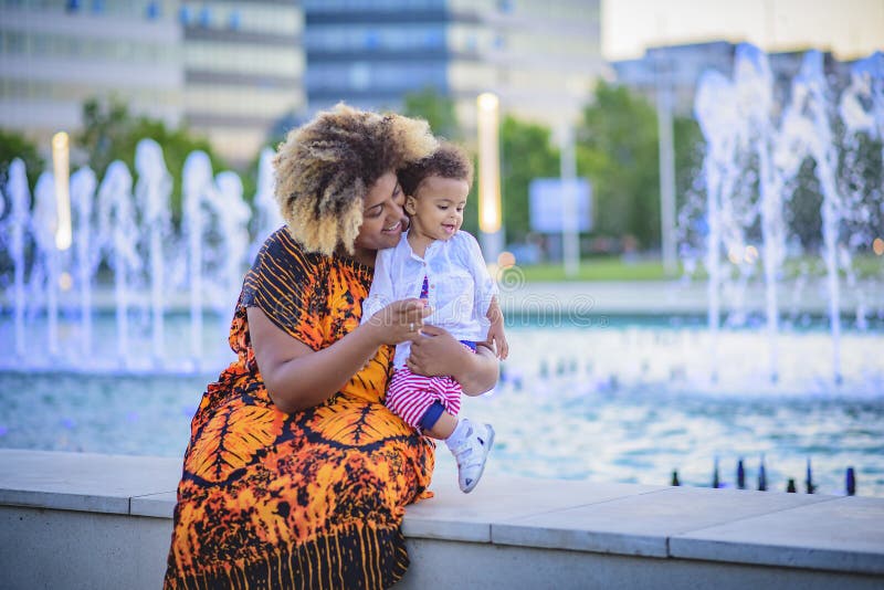 Madre e hija que se divierten con agua de la fuente imagen de archivo