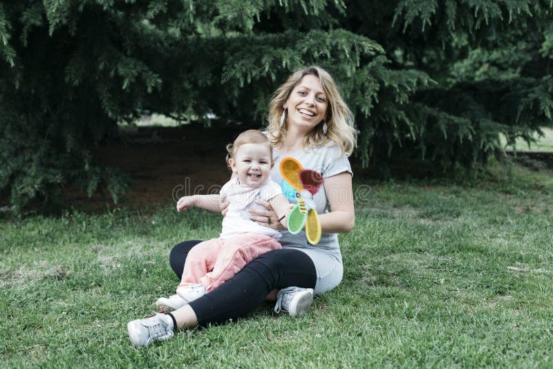 Madre e hija que se sientan en el césped fotos de archivo libres de regalías Madre e hija que se sientan en el césped fotos de archivo libres de regalías