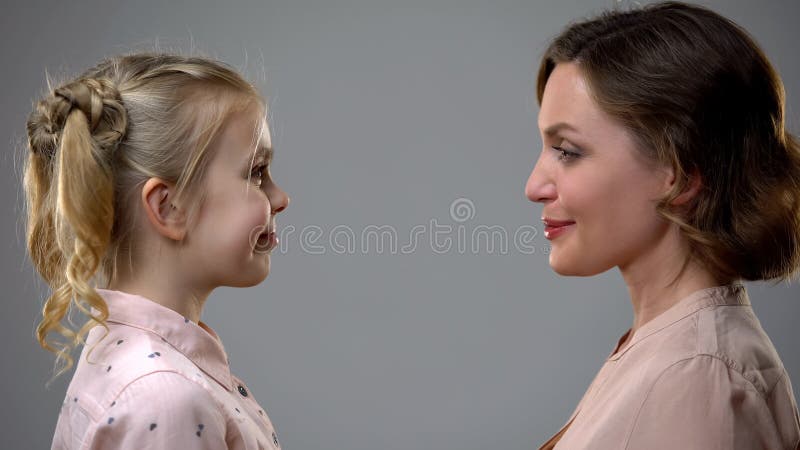 Smiling mother and daughter looking at each other, growing up reflection, stock photo. Smiling mother and daughter looking at each other, growing up reflection, stock photo