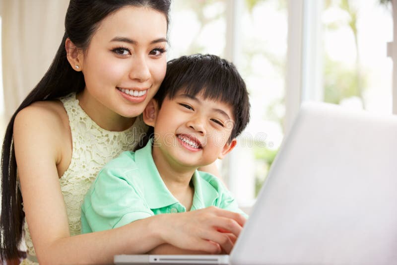 Madre e hijo chinos que usa la computadora portátil imagen de archivo Madre e hijo chinos que usa la computadora portátil imagen de archivo
