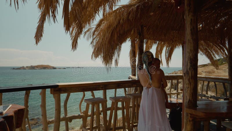 Madre e hijo disfrutando de las vistas al océano desde la cabaña de playa almacen de metraje de vídeo
