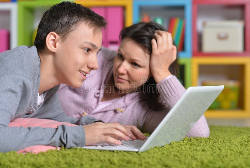 Madre e hijo emocionados con el ordenador port?til moderno foto de archivo Madre e hijo emocionados con el ordenador port?til moderno foto de archivo