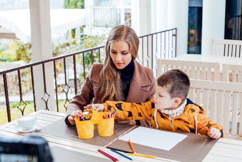 Madre e hijo en el restaurante pintados antes de comer fotografía de archivo libre de regalías
