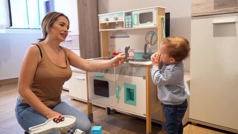 Madre e hijo jugando con la cocina de juguete almacen de video