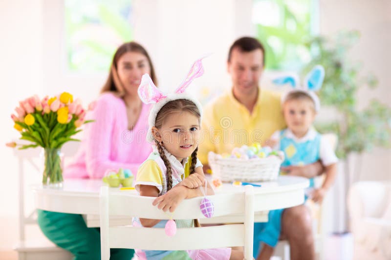 Madre e hijos familia colorear huevos de Pascua imagen de archivo libre de regalías