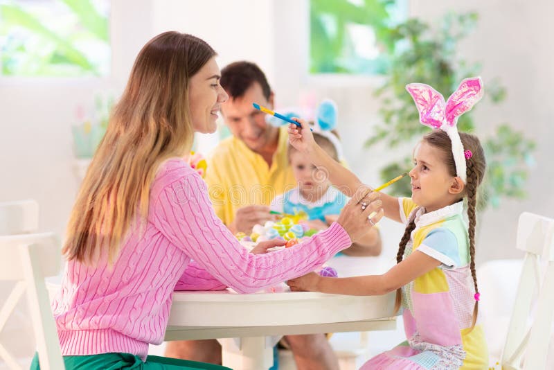 Madre e hijos familia colorear huevos de Pascua foto de archivo libre de regalías