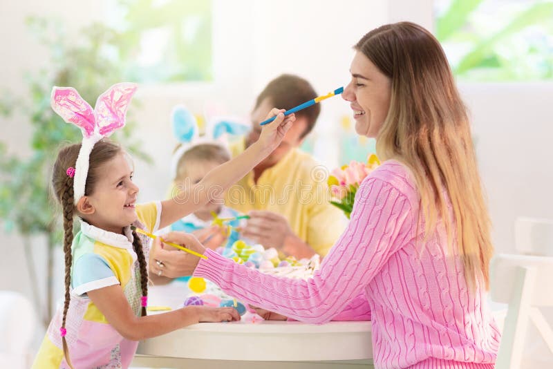 Madre e hijos familia colorear huevos de Pascua imágenes de archivo libres de regalías