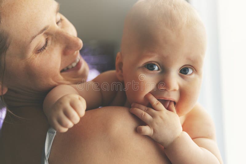 Madre felice con il neonato sopra la spalla fotografia stock Madre felice con il neonato sopra la spalla fotografia stock