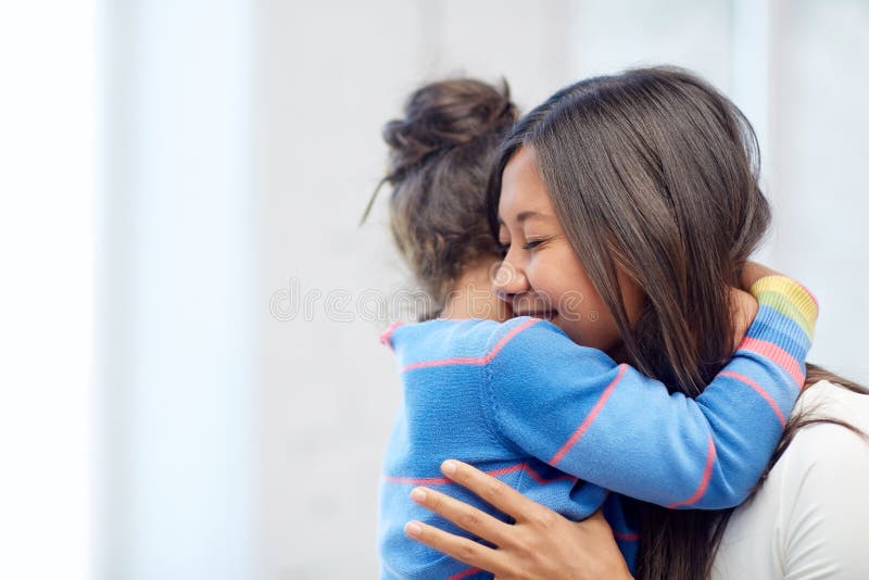 Madre felice e figlia che abbracciano a casa fotografia stock libera da diritti Madre felice e figlia che abbracciano a casa fotografia stock libera da diritti