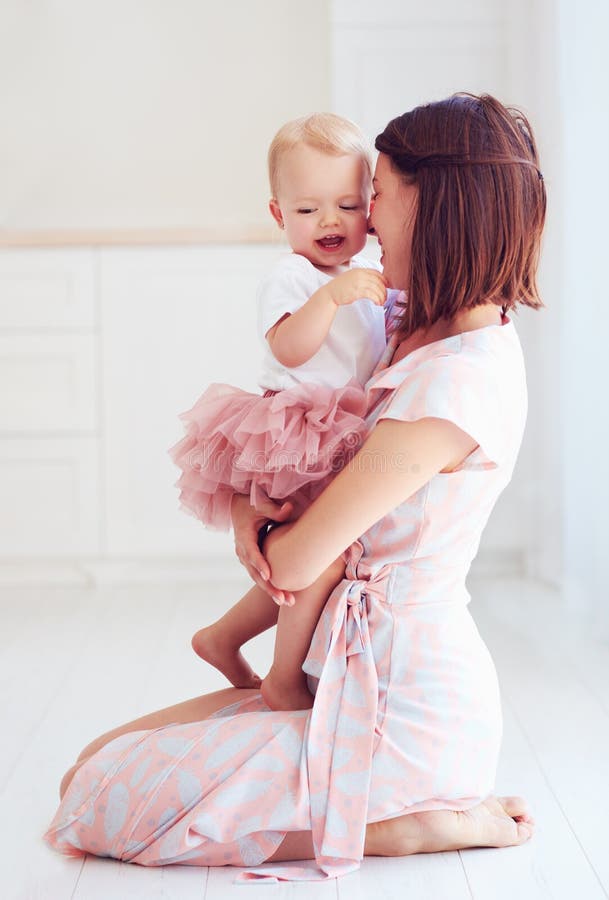 Madre feliz que abraza a su pequeño bebé en casa imagenes de archivo Madre feliz que abraza a su pequeño bebé en casa imagenes de archivo