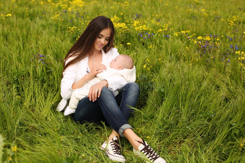Madre hermosa que se divierte con su pequeño bebé lindo en jardín del verano foto de archivo Madre hermosa que se divierte con su pequeño bebé lindo en jardín del verano foto de archivo