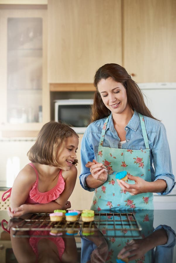 Madre hijo y pastelitos cocinando en casa o como postre de hielo como decoración aprendizaje o unión. la hija de la mujer y foto de archivo libre de regalías