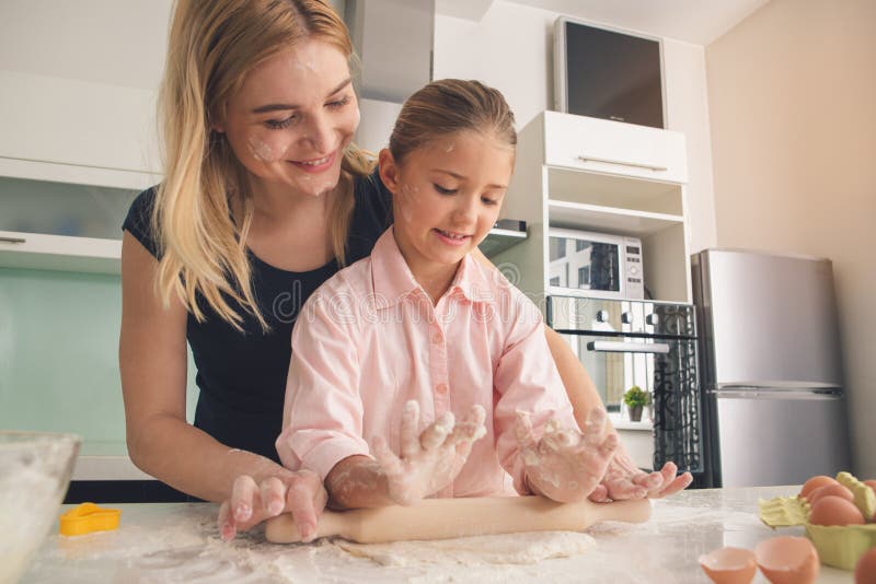 Madre joven e hija que cocinan la pasta junta fotos de archivo Madre joven e hija que cocinan la pasta junta fotos de archivo