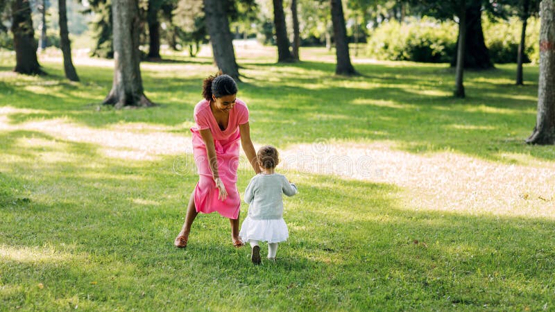 Madre joven jugando en el parque imagen de archivo