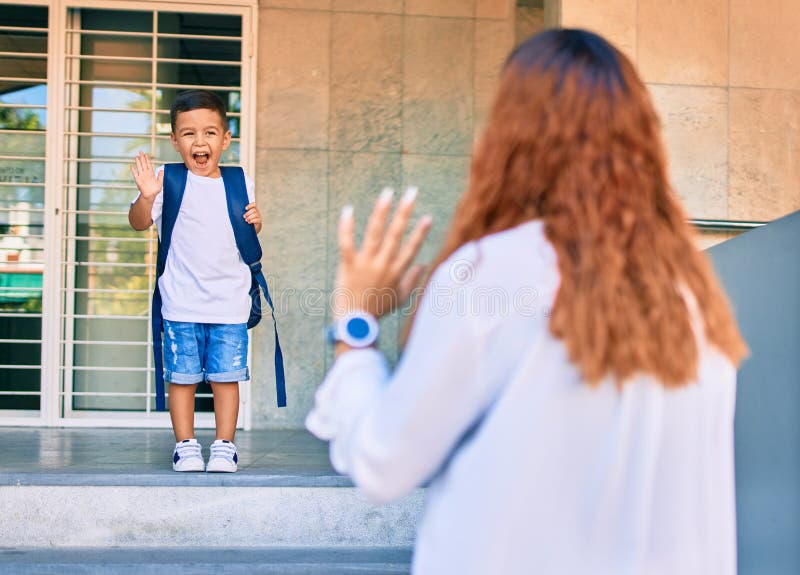Madre latina despidiendo a su hijo estudiante en el colegio fotografía de archivo