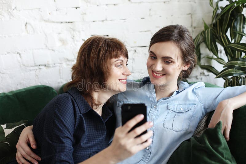Madre matura e sua la figlia che fanno un selfie facendo uso dello Smart Phone immagine stock Madre matura e sua la figlia che fanno un selfie facendo uso dello Smart Phone immagine stock