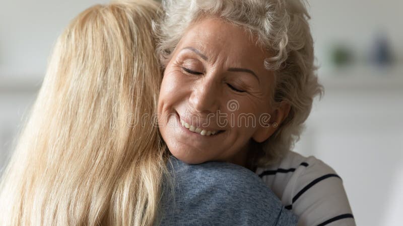 Madre matura felice abbraccia la figlia adulta