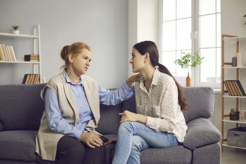 Madre mayor hablando con su hija pequeña dándole consejos y apoyándola