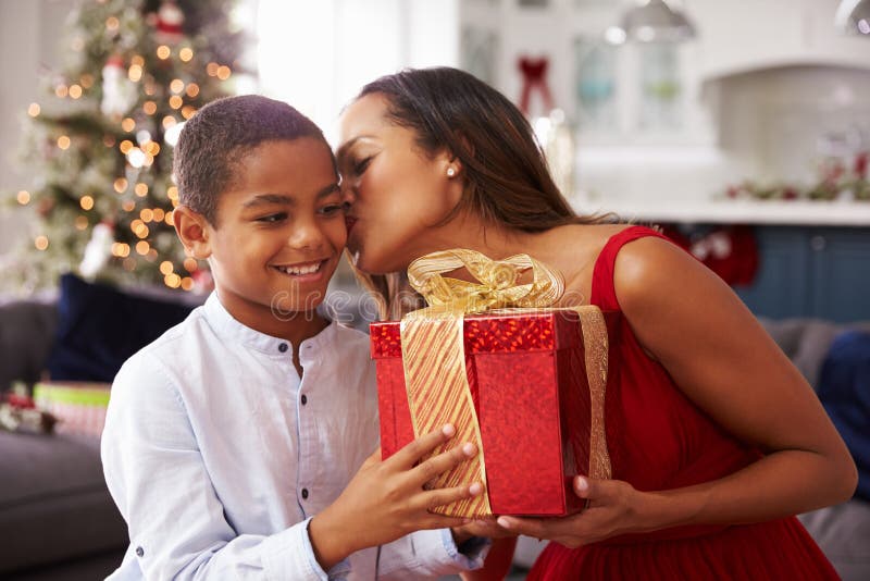 Madre que da regalos de Navidad al hijo en casa foto de archivo libre de regalías Madre que da regalos de Navidad al hijo en casa foto de archivo libre de regalías