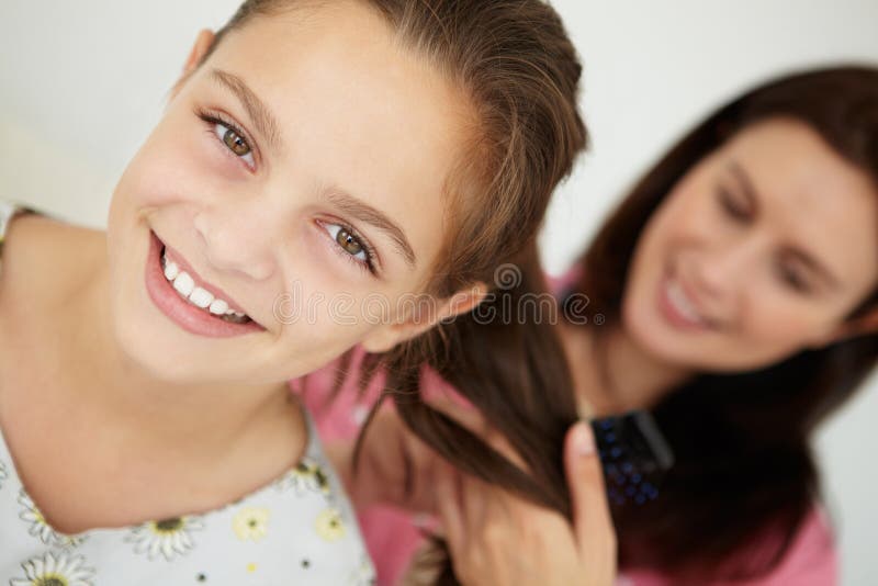 Madre que peina el pelo de la hija fotografía de archivo Madre que peina el pelo de la hija fotografía de archivo