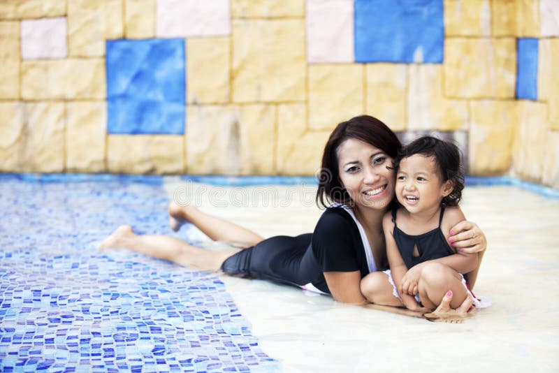 Madre que tiene un rato de la calidad en la piscina imagen de archivo libre de regalías Madre que tiene un rato de la calidad en la piscina imagen de archivo libre de regalías