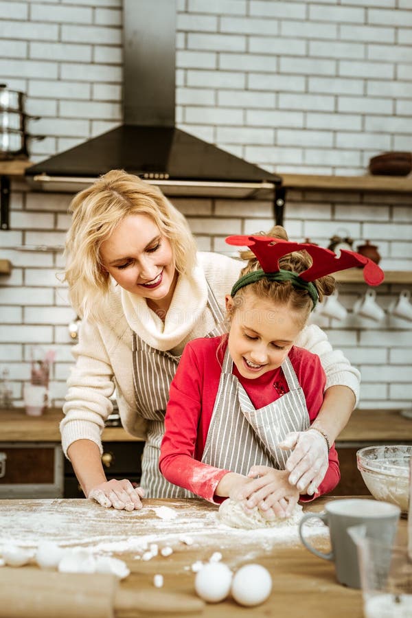 Madre sonriente Amused atento que mira en diligencia de su niño imágenes de archivo libres de regalías Madre sonriente Amused atento que mira en diligencia de su niño imágenes de archivo libres de regalías