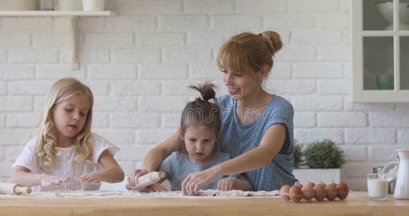 Madre sorridente che insegna pasticceria alle figlie stock footage