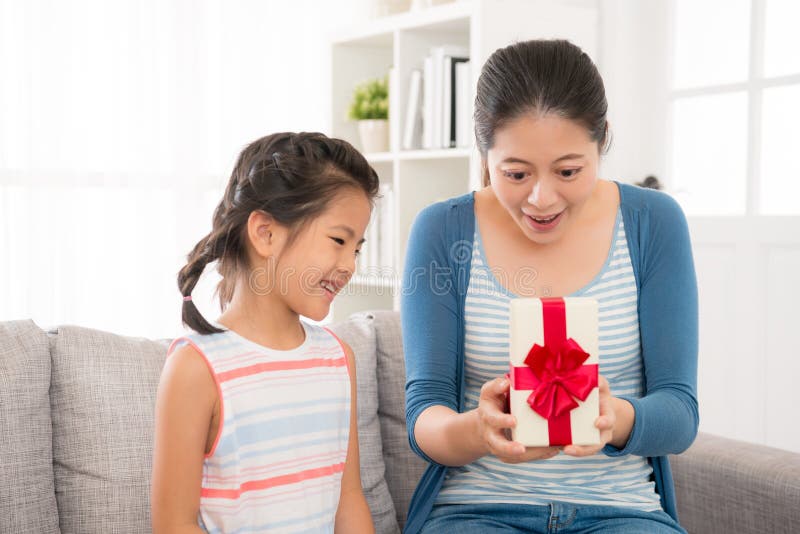 Madre tocada feliz de abrir el regalo de la hija foto de archivo libre de regalías Madre tocada feliz de abrir el regalo de la hija foto de archivo libre de regalías