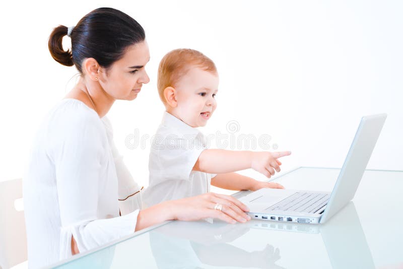 Madre y bebé que usa la computadora portátil imagen de archivo libre de regalías Madre y bebé que usa la computadora portátil imagen de archivo libre de regalías