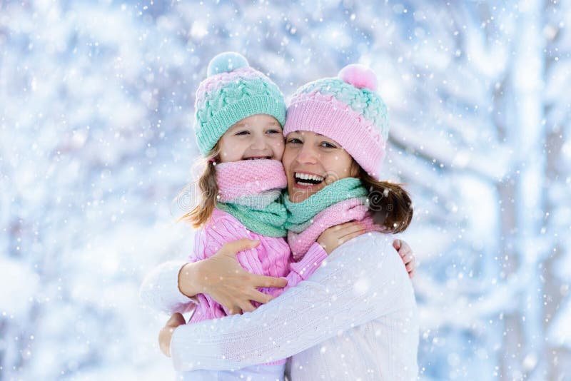 Madre y niño en sombreros hechos punto del invierno en nieve foto de archivo libre de regalías Madre y niño en sombreros hechos punto del invierno en nieve foto de archivo libre de regalías