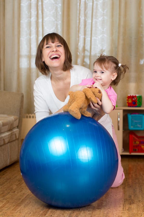Madre y niño que juegan con el hogar de la bola de la aptitud foto de archivo libre de regalías Madre y niño que juegan con el hogar de la bola de la aptitud foto de archivo libre de regalías