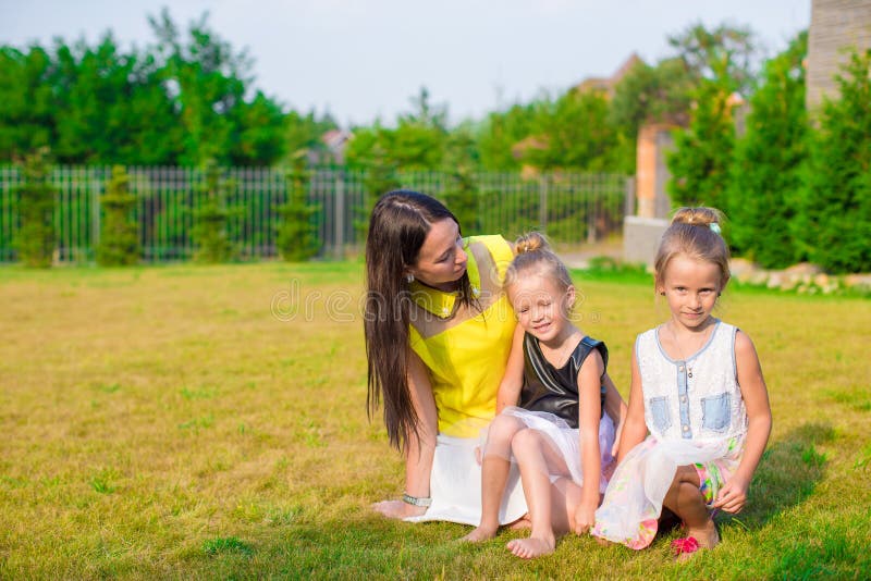 Madre y niños que se sientan al aire libre en hermoso fotos de archivo libres de regalías Madre y niños que se sientan al aire libre en hermoso fotos de archivo libres de regalías