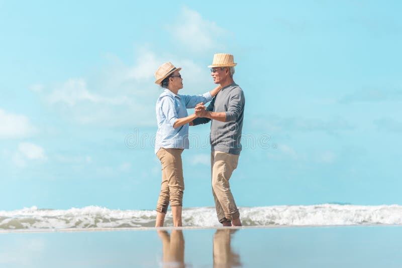 Madres maduras, hijos bailando en la playa fotografía de archivo libre de regalías Madres maduras, hijos bailando en la playa fotografía de archivo libre de regalías