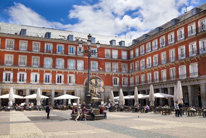 MADRID, SPAIN - MAY 28, 2014: cafe on Plaza Mayor and Statue of Philip III in foront of his house