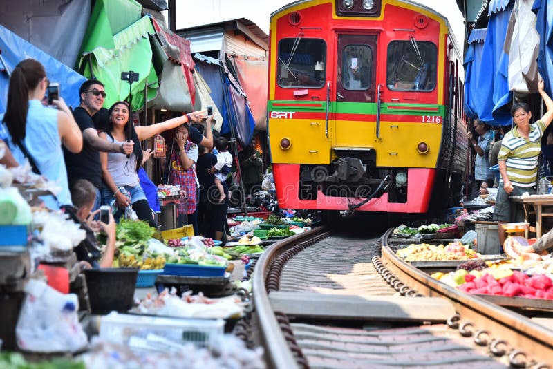 Train passing through Maeklong railway market, Thailand