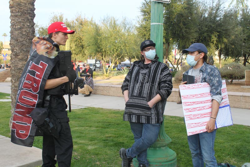 Phoenix, Ariz. / USA - Jan 6, 2021: Trump supporter Evan Nichols, 20, discusses perspectives to counter protestors during a rally at the State Capitol on the same day others storm the US Capitol in DC. Phoenix, Ariz. / USA - Jan 6, 2021: Trump supporter Evan Nichols, 20, discusses perspectives to counter protestors during a rally at the State Capitol on the same day others storm the US Capitol in DC