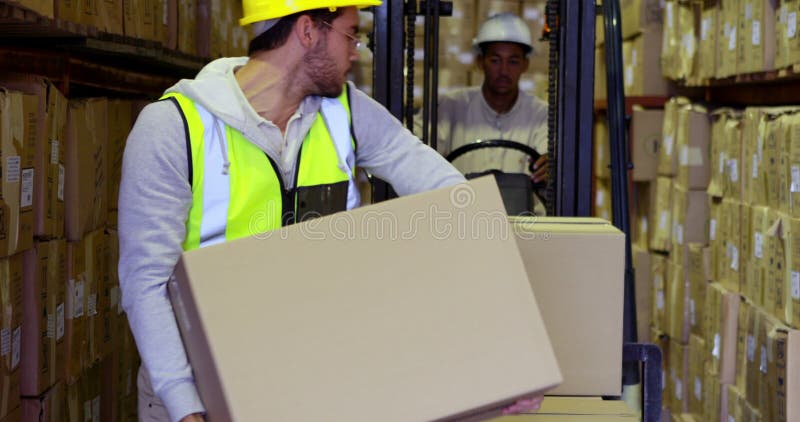 Magazynowi pracownika kocowania pudełka na forklift