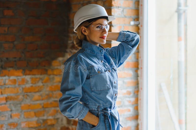 Magazziniere. donna costruttrice di hardhat. ingegnere o architetto femmina. ristrutturazione a domicilio. ispettore qualità fotografie stock