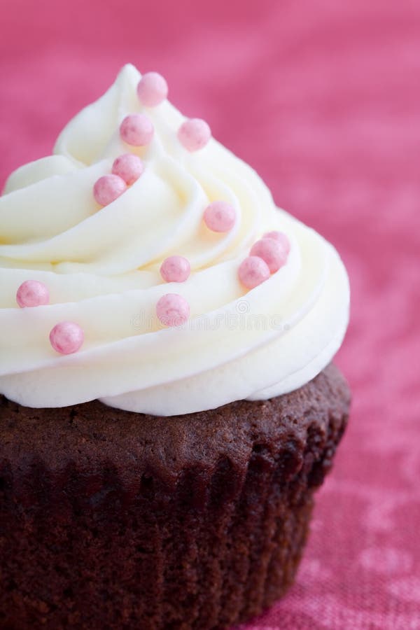 Chocolate cupcake decorated with pink dragees. Chocolate cupcake decorated with pink dragees