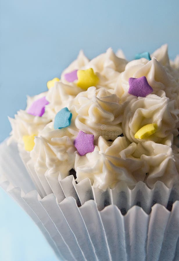 Starry Delight: A delectable cupcake topped with multicolored star-shaped sprinkles nestled atop a smooth vanilla buttercream icing. Against a serene blue backdrop, this sweet treat promises a burst of flavor and whimsy, capturing the essence of pure joy in every bite. Starry Delight: A delectable cupcake topped with multicolored star-shaped sprinkles nestled atop a smooth vanilla buttercream icing. Against a serene blue backdrop, this sweet treat promises a burst of flavor and whimsy, capturing the essence of pure joy in every bite.