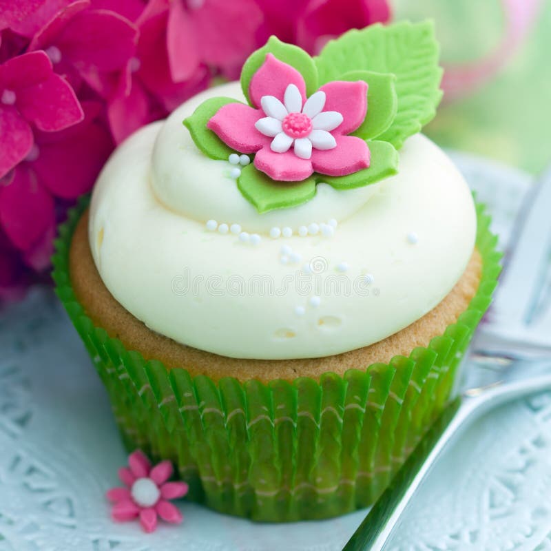 Cupcake decorated with a pink and white sugar flower. Cupcake decorated with a pink and white sugar flower