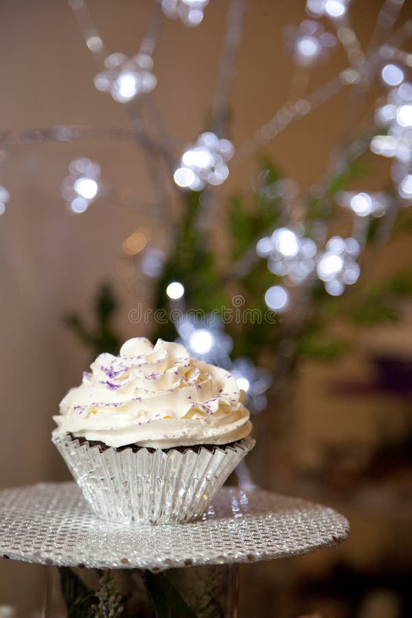 Details of a freshly baked, frosted cupcake in a tinfoil baking wrapper. Details of a freshly baked, frosted cupcake in a tinfoil baking wrapper.