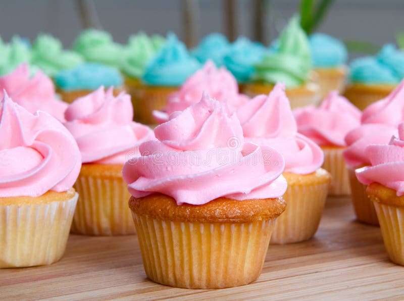 Pink cupcake up close with lots of cupcakes in background. Pink cupcake up close with lots of cupcakes in background