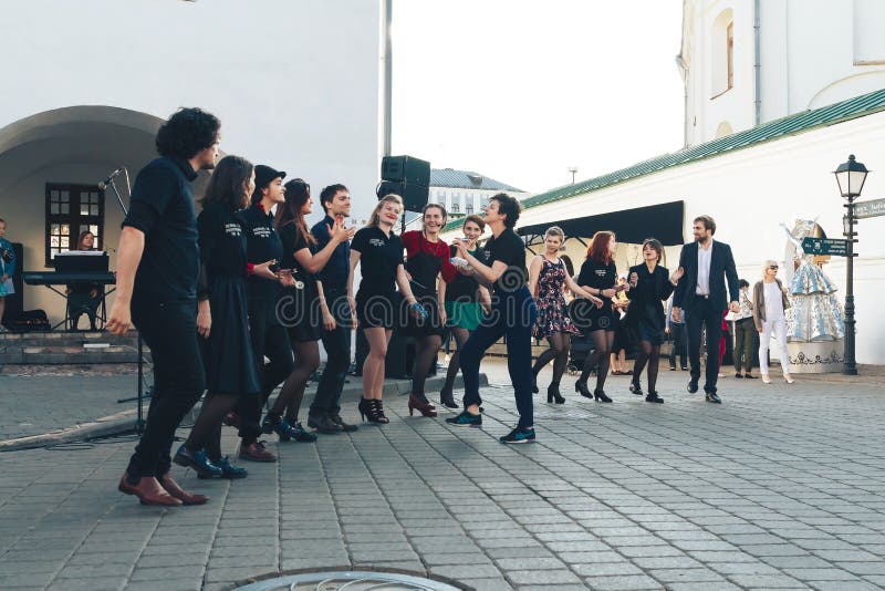 May 25, 2019 Minsk Belarus Street festivities in the evening city A theater troupe and a woman show a theatrical performance in front of people in the square. May 25, 2019 Minsk Belarus Street festivities in the evening city A theater troupe and a woman show a theatrical performance in front of people in the square